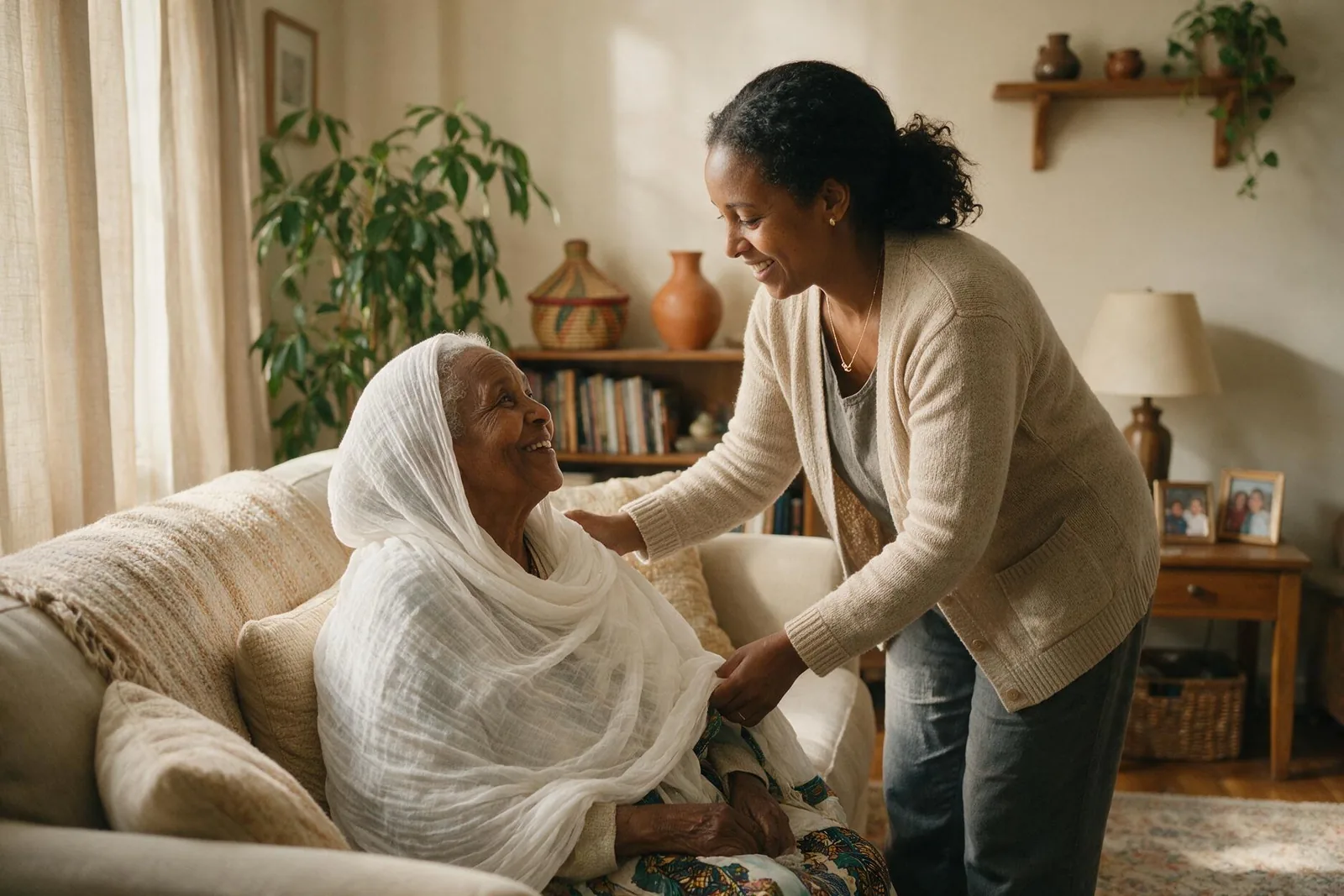 A daughter helping her elderly mother settle onto the sofa at home.